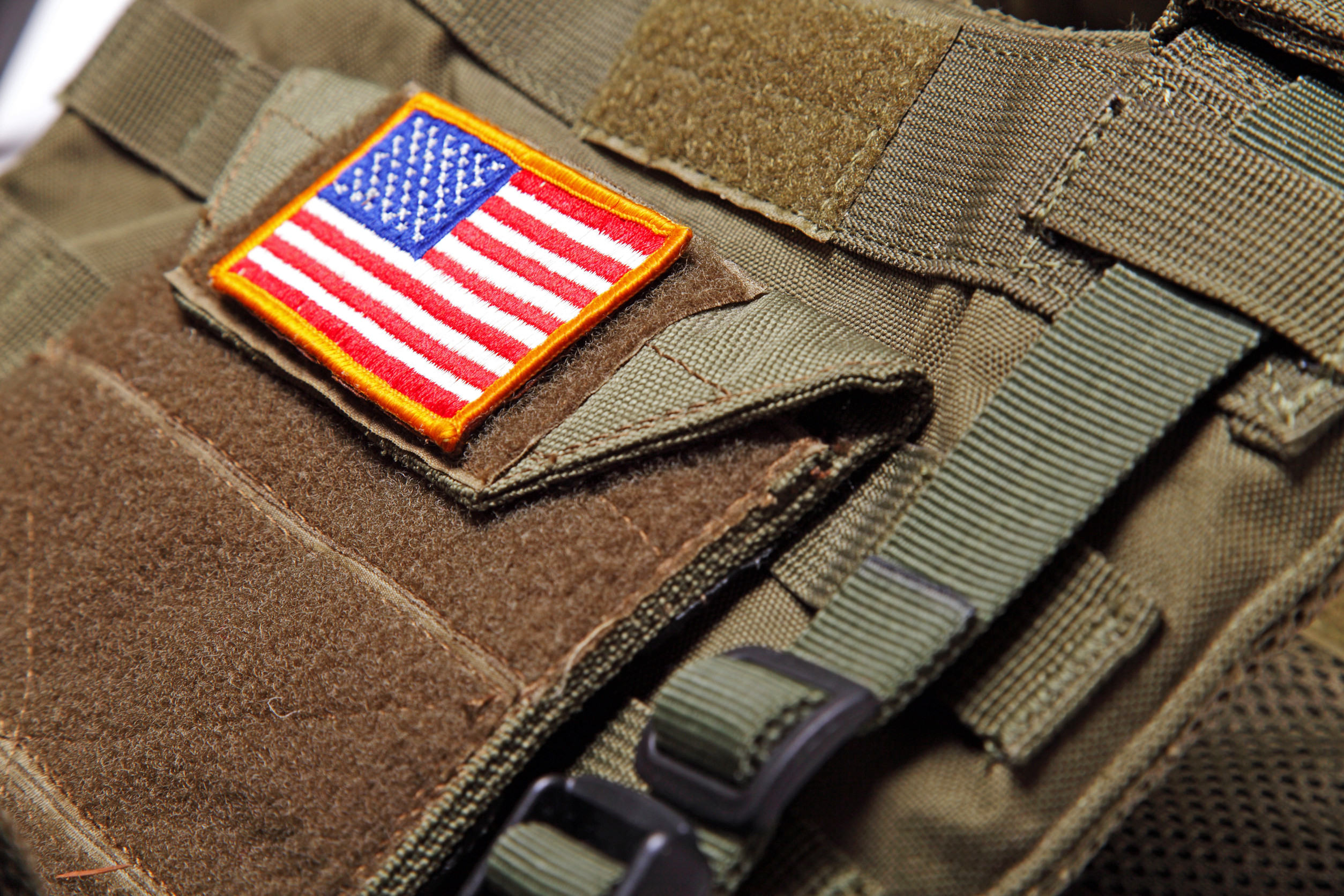 American flag on a green (olive drab) tactical vest. Close-up.